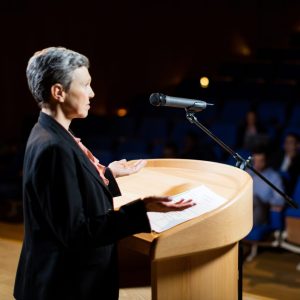 Female business executive giving a speech at conference center
